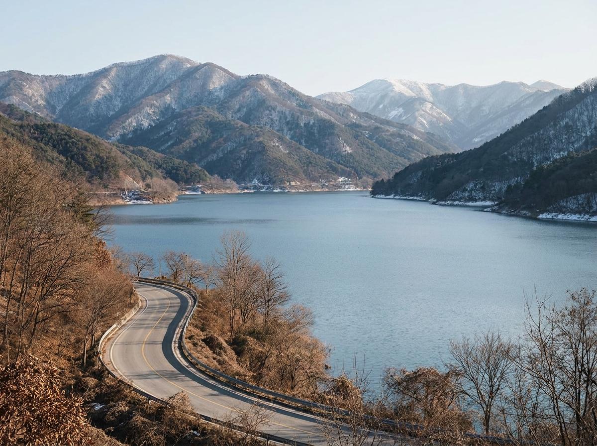 겨울 호수와 산자락을 따라 이어지는 도로를 표현한 이미지